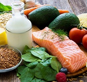 Assortment of foods from various healthy food groups on wooden surface
