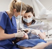 female dentist with assistant working on patient  