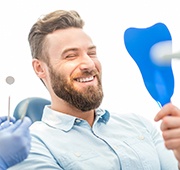 man smiling in dental mirror 