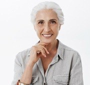 Smiling, mature woman after dental implant supported denture