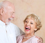 Couple smiling after cost of dentures in Salem 