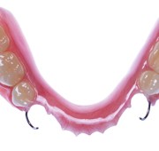 Image of a partial denture, complete with metal clasps in the front to hold it in place