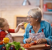 Grandmother and child eating vegetables in Salem