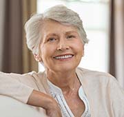 elderly woman smiling with dental implants in Salem