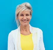 smiling woman in front of a blue background