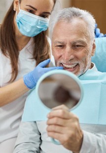 a patient checking his new dental implants near South Central