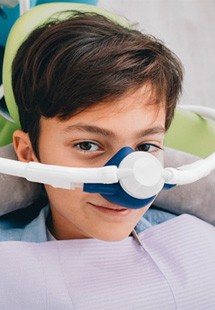 a child smiling while receiving nitrous oxide sedation