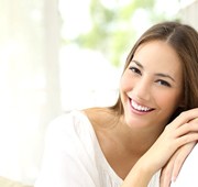 A young woman smiling after teeth whitening in Salem