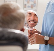 Salem cosmetic dentist showing patient smile in mirror