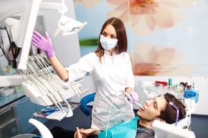 A dentist using an intraoral camera to examine a patient’s mouth.