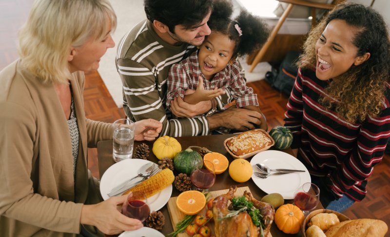 a family seated around a table full of Thanksgiving food 