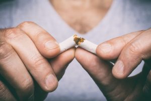 Breaking cigarette, quitting smoking to protect dental implants